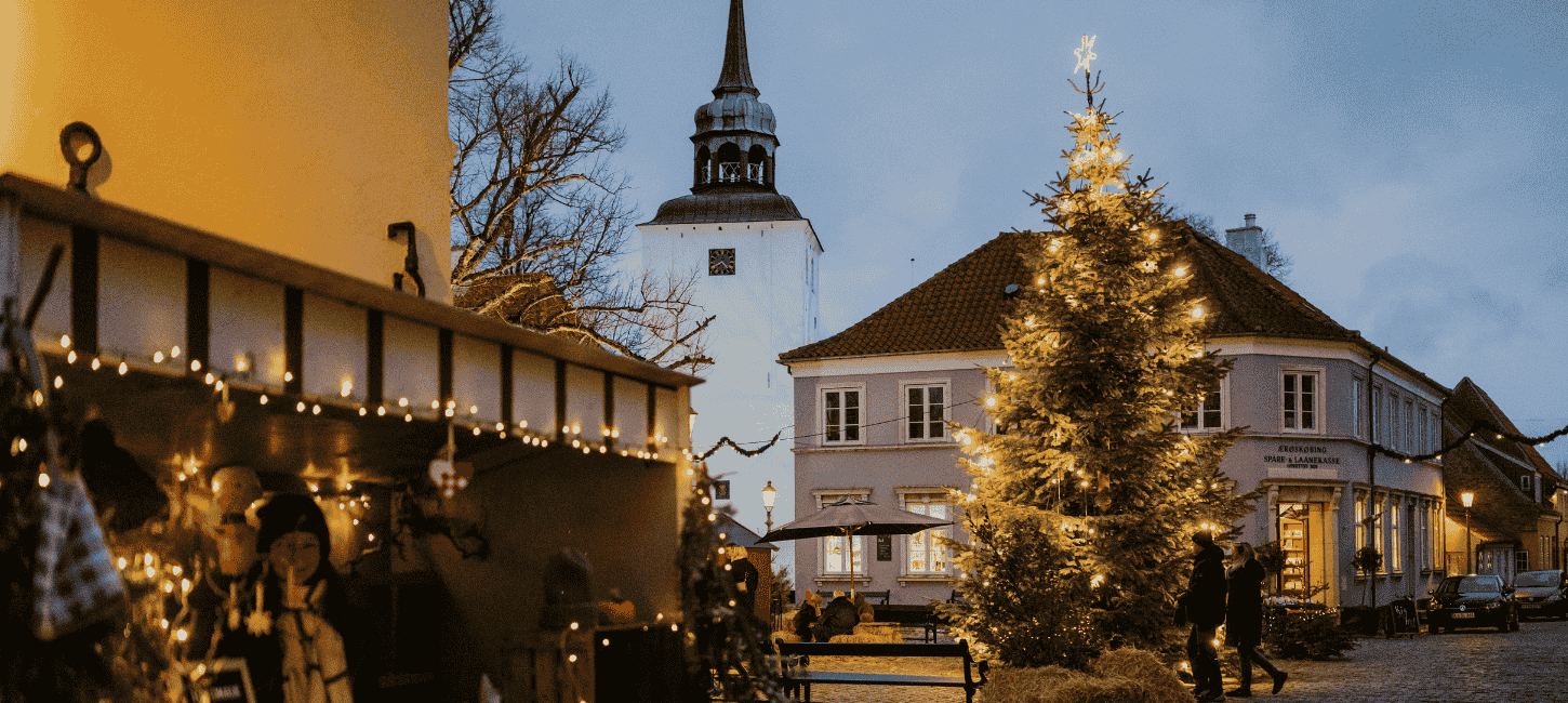 Et bytorv med juledekoration i form af julelys, juletræ og julemarkedboder