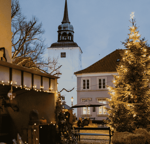 Et bytorv med juledekoration i form af julelys, juletræ og julemarkedboder