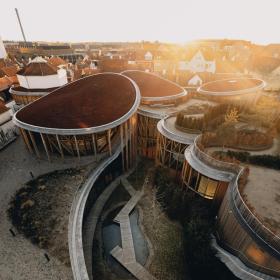 Dronebillede af H.c. Andersens hus museum. Store buede bygninger med haver på tagene. 