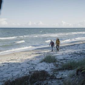 Et par vandrer en tur langs stranden.